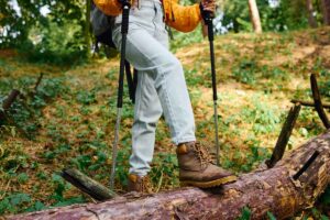 woman explores a forest trail, embracing the beauty of autumn foliage on her hike.
