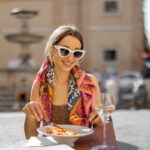 A close up photo of a woman eating pasta in a restaurant in Italy.