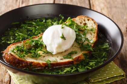 Light green soup with poached egg and bread.