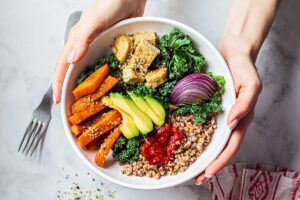 Colorful vegan dish with baked vegetables, avocado and tofu.