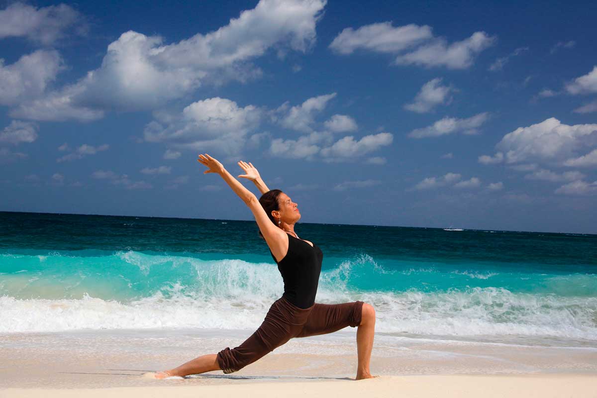 Woman doing yoga on a beach in the Bahamas.