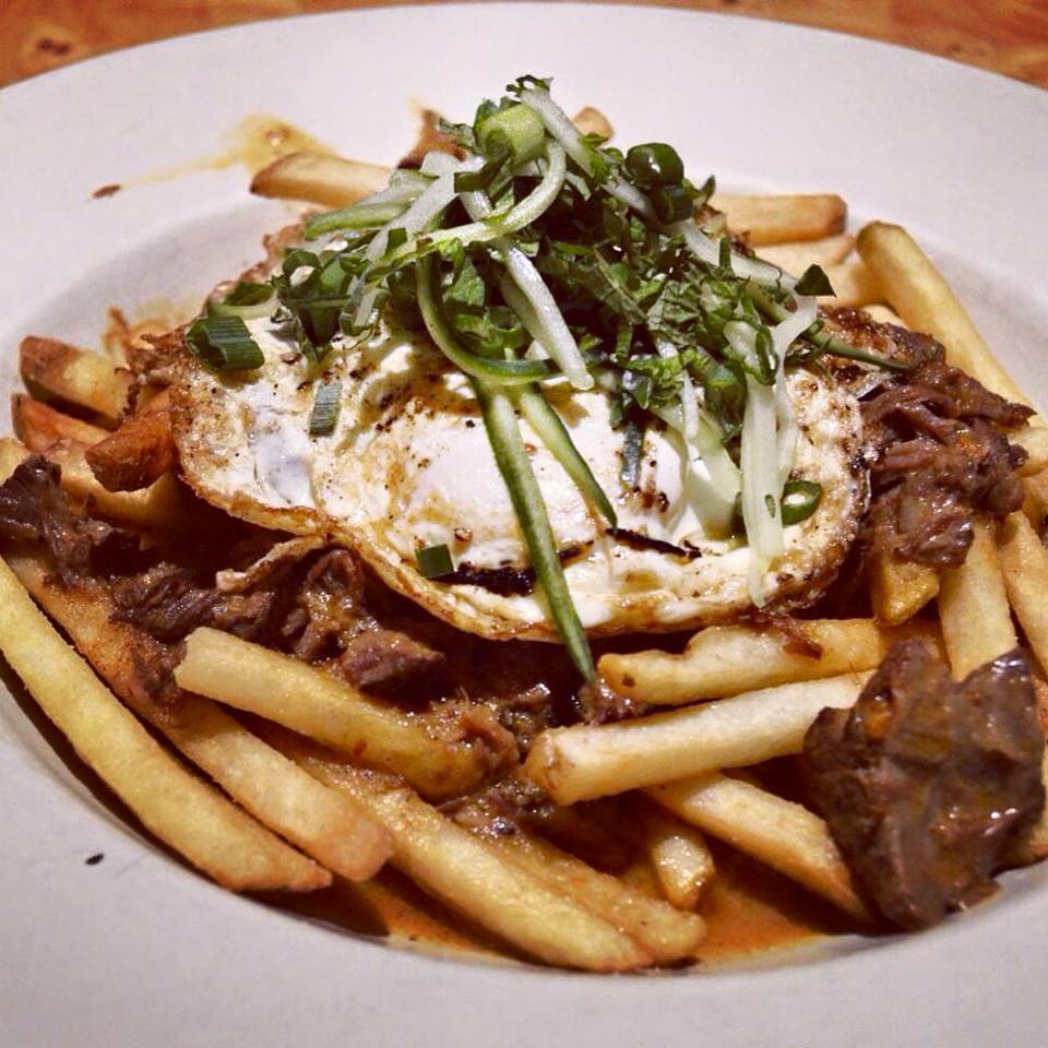 Beef Curry Poutin with a fried egg and chives.  Photo courtesy of Nose Dive.