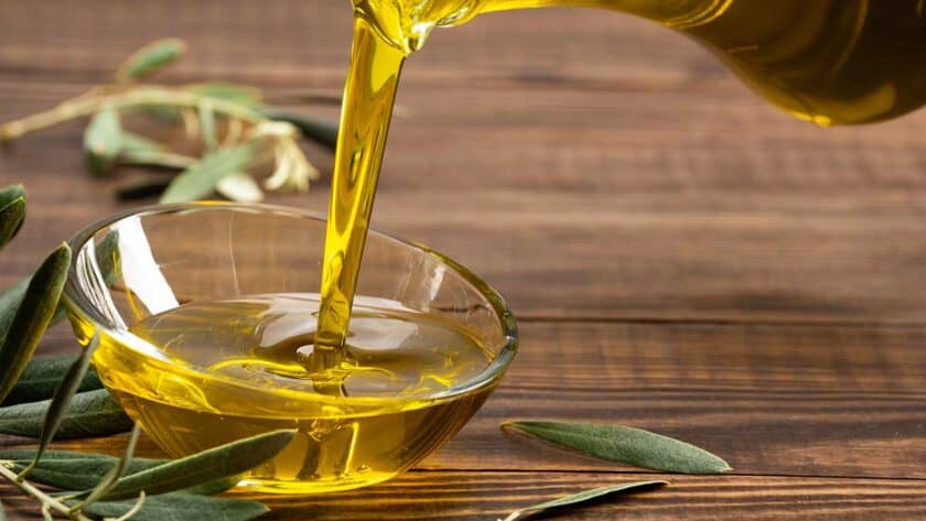 Pouring olive oil into a small glass bowl.