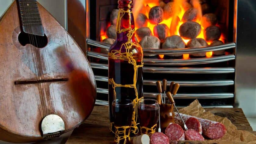 Polish nalewki drink next to salami and a guitar.