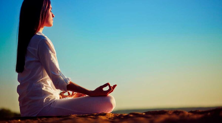 Meditating woman sitting in pose of lotus.