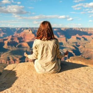 Woman meditating on a cliff