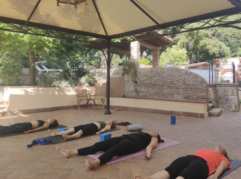 group of people doing yoga outside in the Tuscan countryside