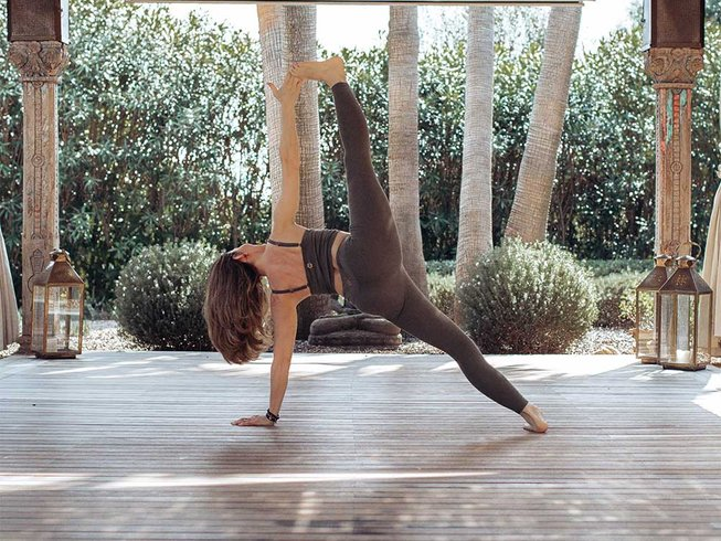 woman doing a challenging yoga pose on a retreat in Mallorca