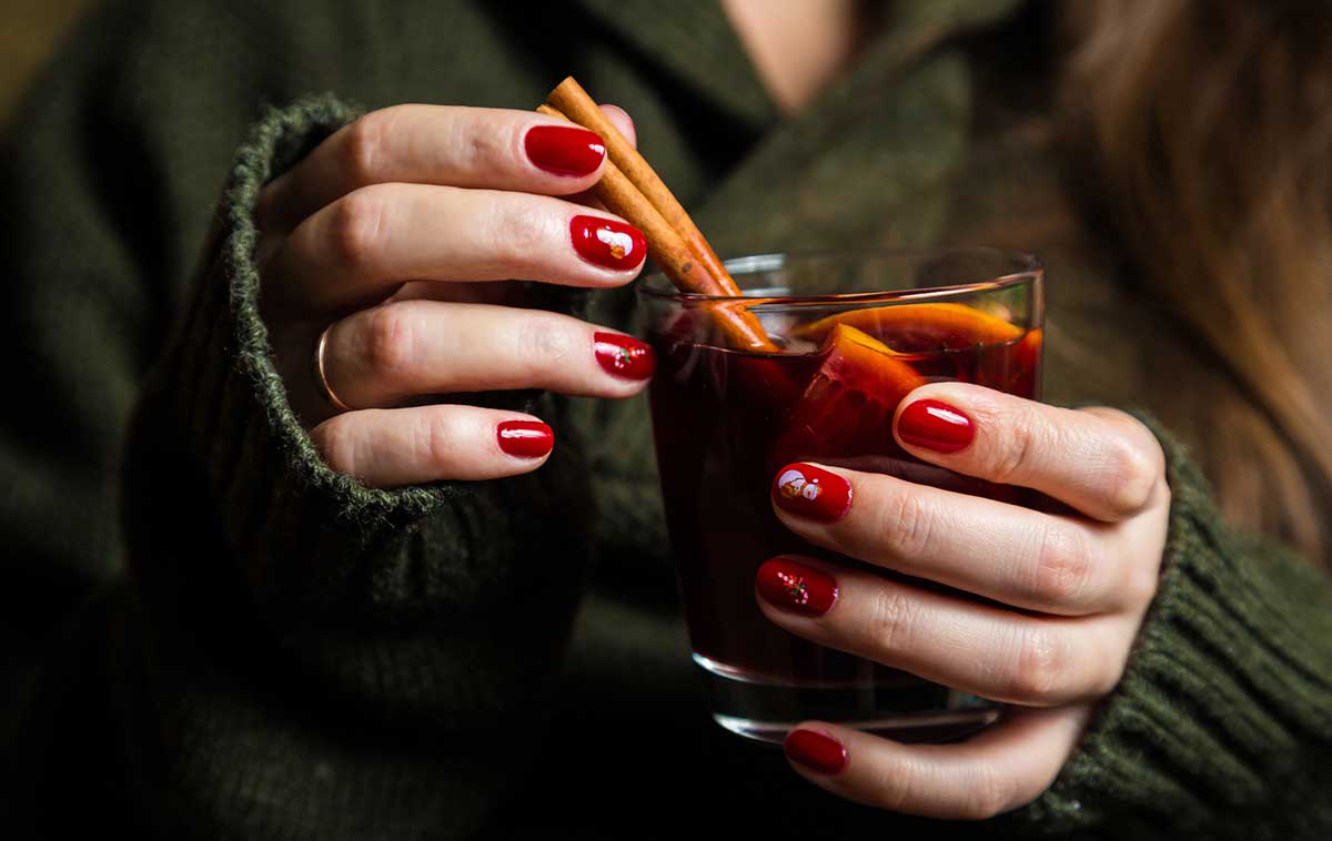 woman holding a glass of mulled wine being made at the Strasbourg Christmas Market