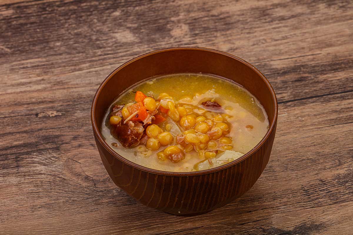 A close up picture of a bowl with bean and corn stew.