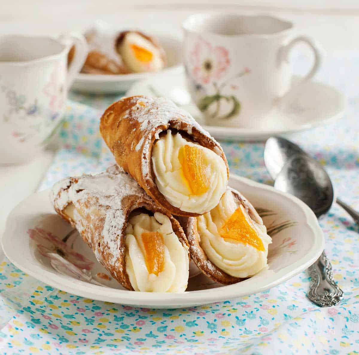 Traditional cannoli in Sicily on a plate dusted with powdered sugar